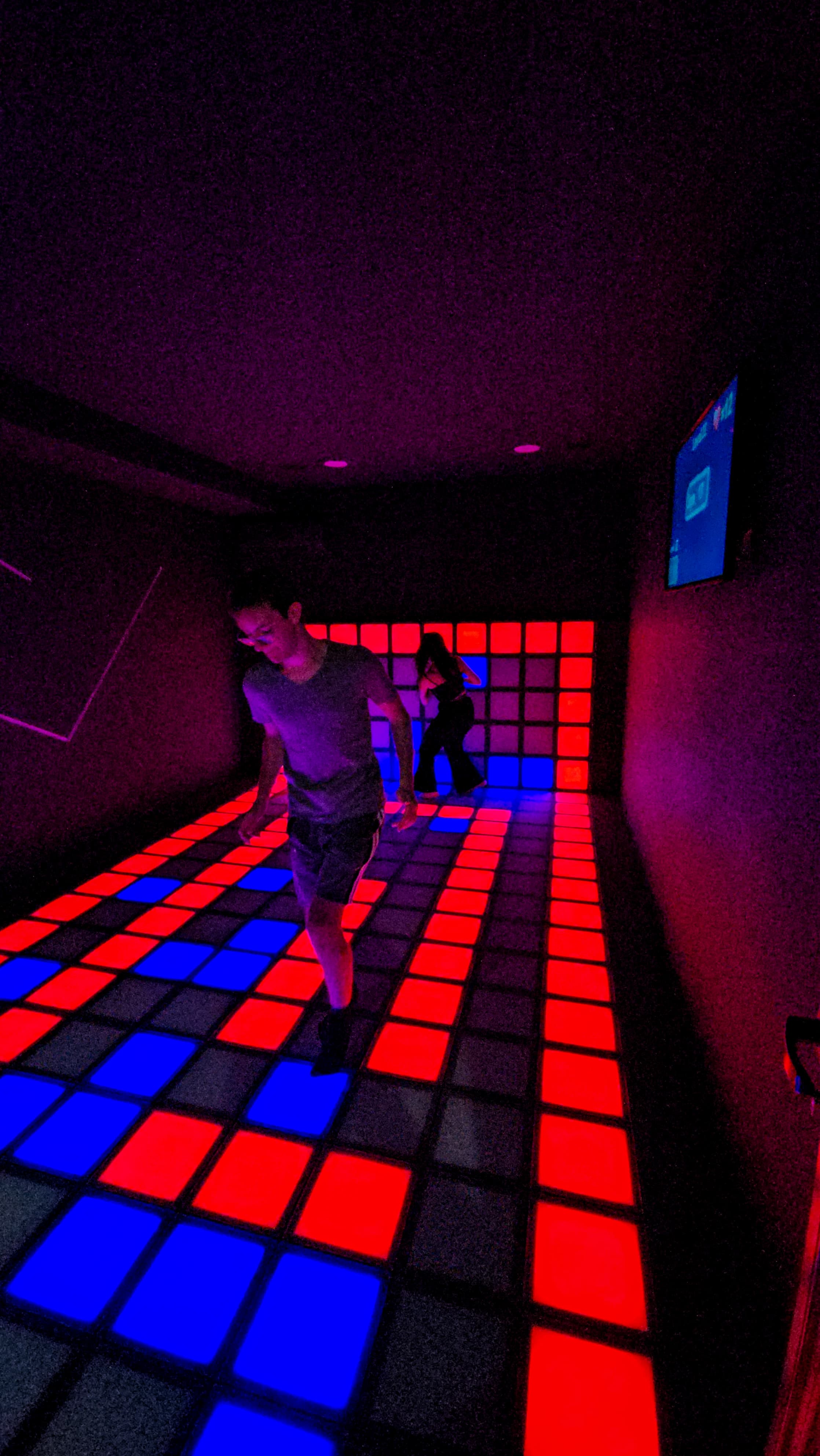 A child playing on the glowing tiles.